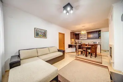 a living room with a couch and a dining room at Slopeview Stay at Grand Monastery in Pamporovo