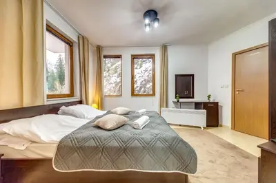 a bedroom with a large bed with two pillows on it at Slopeview Stay at Grand Monastery in Pamporovo