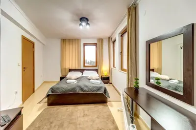 a bedroom with a bed and a large mirror at Slopeview Stay at Grand Monastery in Pamporovo