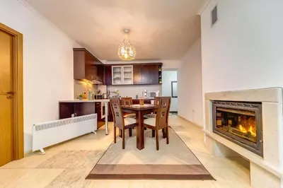 a living room with a table and a fireplace at Slopeview Stay at Grand Monastery in Pamporovo