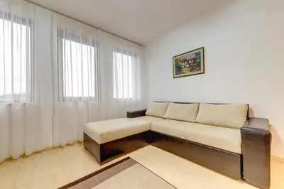 a couch in a room with two windows at Slopeview Stay at Grand Monastery in Pamporovo