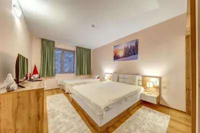a bedroom with two beds and a large window at Cozy Evrika 2 Mountain Home in Pamporovo
