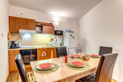 a kitchen with a wooden table with chairs and a dining room at Cozy Evrika 2 Mountain Home in Pamporovo
