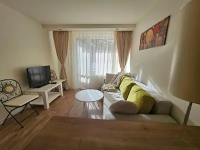 a living room with a couch and a tv at Sunlit Forest Suite in Borovets