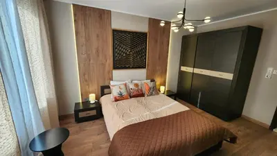 a bedroom with a bed and a black cabinet at SPOMAR One Bedroom Apartment in Bansko
