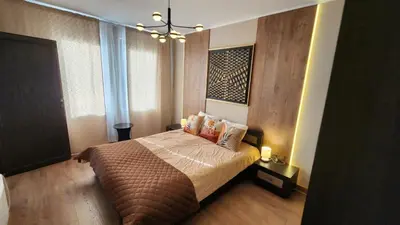 a bedroom with a bed and a chandelier at SPOMAR One Bedroom Apartment in Bansko