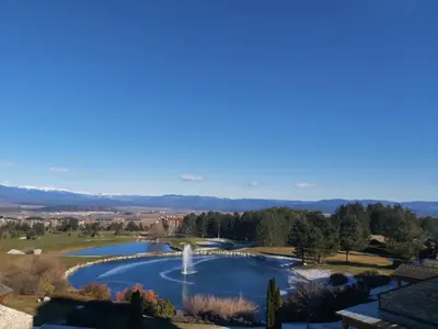 a view of a pond with a fountain at Tranquility Apartment Pirin Golf in Razlog