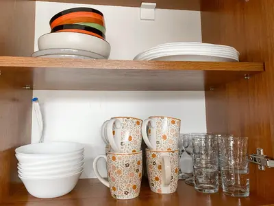 a shelf with cups and plates and bowls on it at Evergreen Private Apartment 303 in Bansko