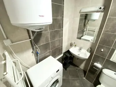 a bathroom with a washing machine and a sink at Evergreen Private Apartment 303 in Bansko