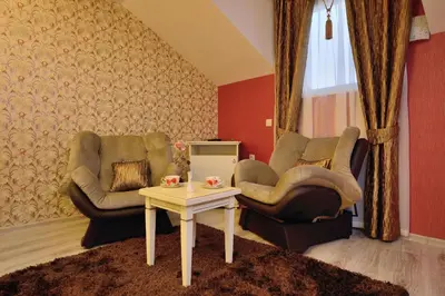 a living room with two chairs and a table at Villa Paris in Hisarya