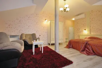 a bedroom with a bed and a couch and a table at Villa Paris in Hisarya