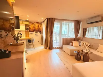 a living room with a couch and a kitchen at Lux Boutique 2 BDR apartment right next ski gondola lift in Bansko
