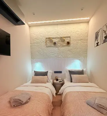two beds sitting next to each other in a bedroom at Lux Boutique 2 BDR apartment right next ski gondola lift in Bansko