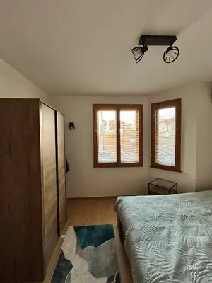 a bedroom with a bed and two windows at Cu29 Kapana art Apartments in Plovdiv
