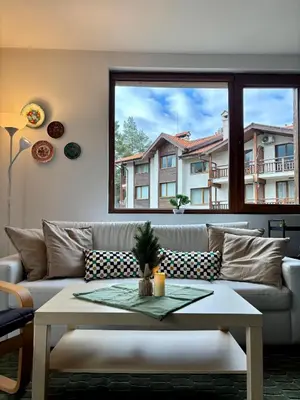 a living room with a couch and a table at Kosara Apartment Home2Host in Bansko