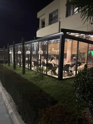 a group of people sitting at tables outside a building at Мотел КОМПЛЕКС GRILL and CHILL in Levunovo