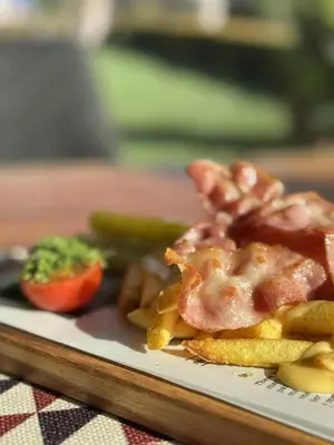 a plate of food with french fries and a tomato at Мотел КОМПЛЕКС GRILL and CHILL in Levunovo