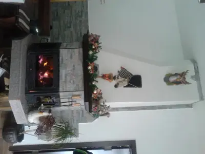 a fireplace with christmas decorations on the wall at Rodopsko Katche in Alamovtsi