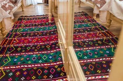 a row of colorful blankets sitting on the floor at Rodopsko Katche in Alamovtsi