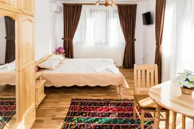 a small bedroom with a bed and a table at Rodopsko Katche in Alamovtsi