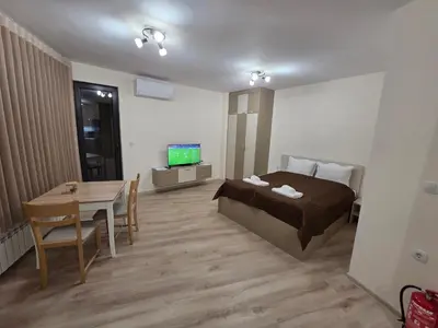 a bedroom with a bed and a table and a television at Apartment Aria 7 in Velingrad