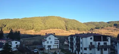 a group of houses in front of a mountain at Amore Grande in Beli Iskar