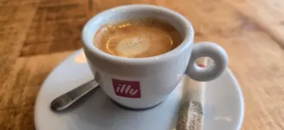 a cup of coffee on a plate on a table at Amore Grande in Beli Iskar