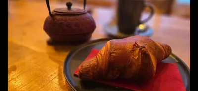 a glass plate with a croissant on a table at Amore Grande in Beli Iskar