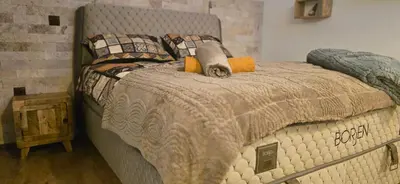 a bedroom with a large bed with a gray bedspread at Amore Grande in Beli Iskar