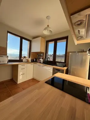 a large kitchen with white cabinets and windows at Къща за гости Пегас in Velingrad
