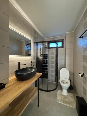 a bathroom with a black sink and a toilet at Къща за гости Пегас in Velingrad
