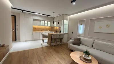 a living room with a couch and a kitchen at Lux Living Apartments in Plovdiv