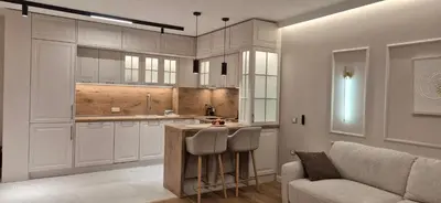a kitchen with white cabinets and a table and a couch at Lux Living Apartments in Plovdiv