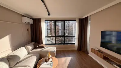 a living room with a couch and a flat screen tv at Lux Living Apartments in Plovdiv