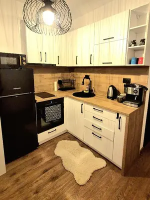 a kitchen with white cabinets and a black refrigerator at Kapana Garden - 4 persons luxury apartment in Plovdiv