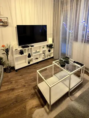 a living room with a tv and a glass coffee table at Kapana Garden - 4 persons luxury apartment in Plovdiv