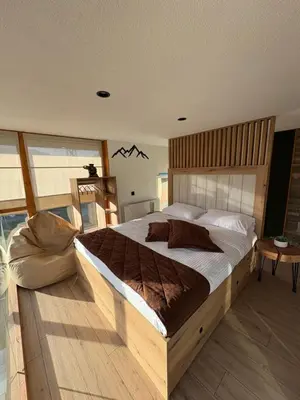 a bedroom with a large bed with a wooden headboard at Loft Chalet Bansko in Bansko