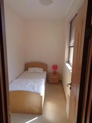 a small bedroom with a bed and a red lamp at Bansko View 3 in Bansko