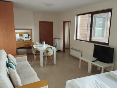 a living room with a couch and a table and a television at Bansko View 3 in Bansko