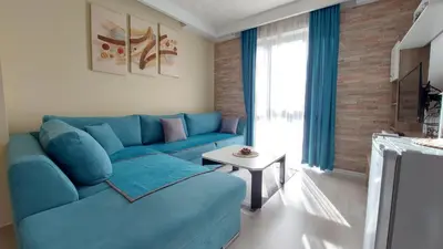 a living room with a blue couch and a table at Аpartment C103 Grand Bansko 1 in Bansko