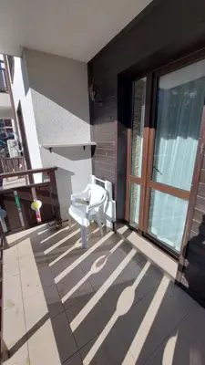 a white chair sitting on the porch of a house at Аpartment C103 Grand Bansko 1 in Bansko