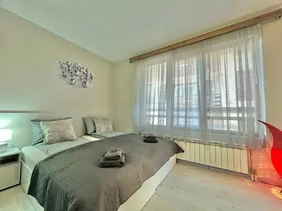 a bedroom with a large bed and a large window at 2BR Snowflake Stay Bansko by SI Stay in Bansko