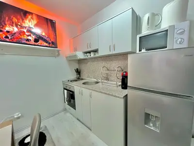 a kitchen with a refrigerator and a fire in the wall at 2BR Snowflake Stay Bansko by SI Stay in Bansko