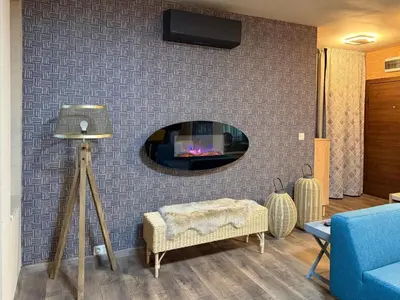 a living room with a wall with a fireplace at Plovdiv ArtNest - 1-Bedroom Cozy Apartments in Plovdiv