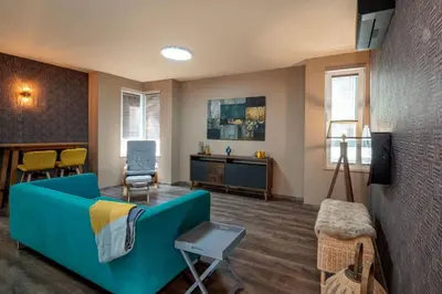 a living room with a blue couch and chairs at Plovdiv ArtNest - 1-Bedroom Cozy Apartments in Plovdiv