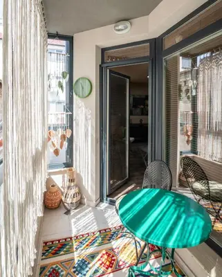 a room with a table and chairs on a balcony at Plovdiv ArtNest - 1-Bedroom Cozy Apartments in Plovdiv