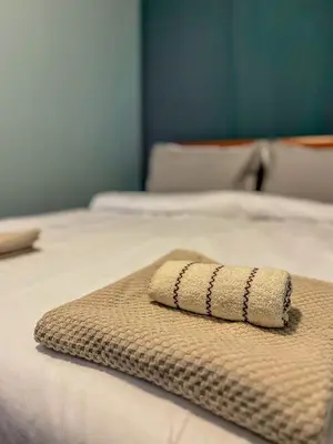 a towel is sitting on top of a bed at Fireplace Apartment near Bus & Train Station in Bansko
