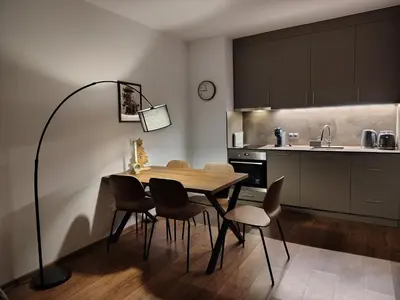 a dining room with a table and chairs in a kitchen at Family Apartment Royal Tower in Bansko