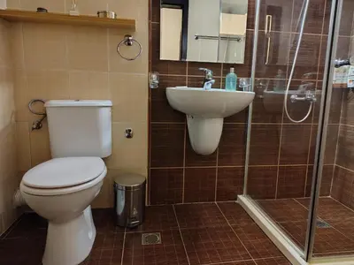 a bathroom with a toilet and a sink and a shower at Family Apartment Royal Tower in Bansko