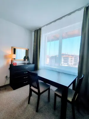 a dining room table with two chairs and a window at Family Apartment Royal Tower in Bansko